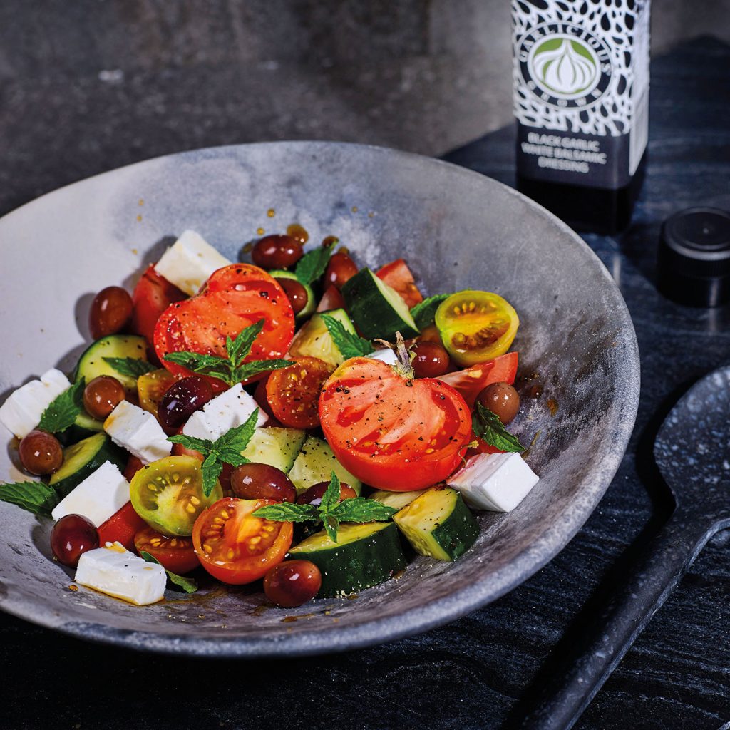 Vegan Greek Salad with a mix of heirloom and cherry tomatoes, vegan feta and Black Garlic White Balsamic Dressing